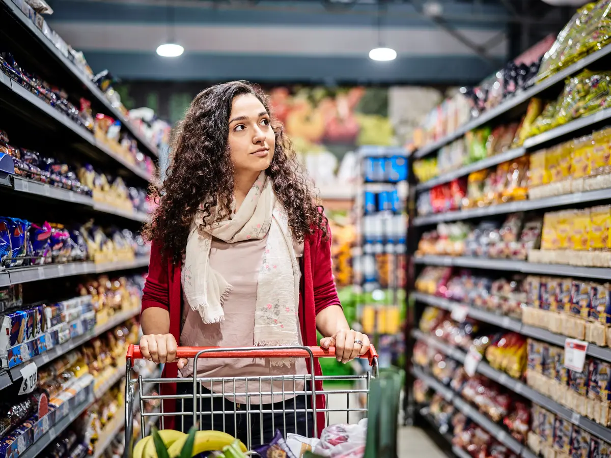 Shopper with a trolley in a supermarket aisle